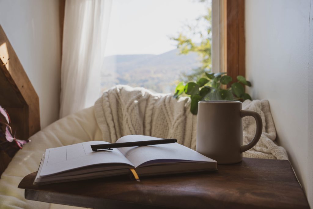 A journal, pen, and candle in soft light, representing the beginning of intuition development.