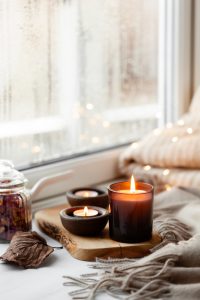 Lit candle by a window for spiritual house cleansing and peaceful home energy